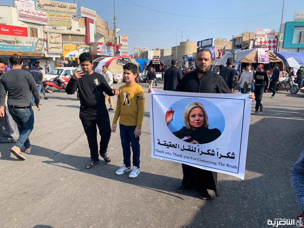 بالصورة: متظاهر في الناصرية يحمل صورة “بلاسخارت” ويشكرها لانها نقلت الحقيقة