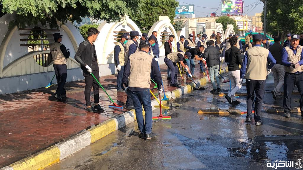 بالصور: الشرطة والمتظاهرون يقومون بحملة لتنظيف الشوارع والجسور في الناصرية