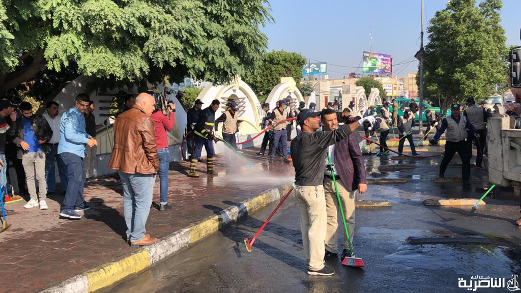 بالصور: الشرطة والمتظاهرون يقومون بحملة لتنظيف الشوارع والجسور في الناصرية