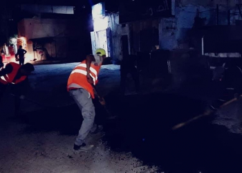 عمال يقومون ب اكساء الشوارع
