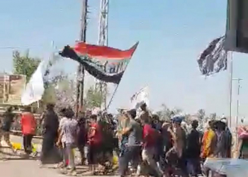 متظاهرون يحملون علم العراق 
