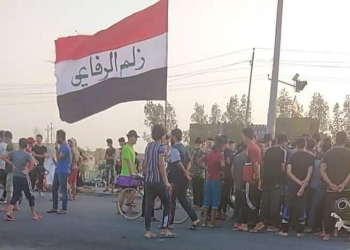 متظاهرون يرفعون علم العراق في قضاء الرفاعي