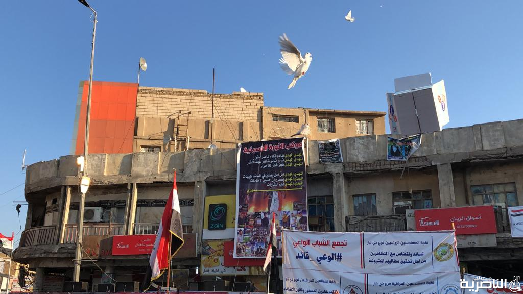 بالصور: متظاهرو الناصرية يطلقون الطيور في ساحة الحبوبي من اجل السلام