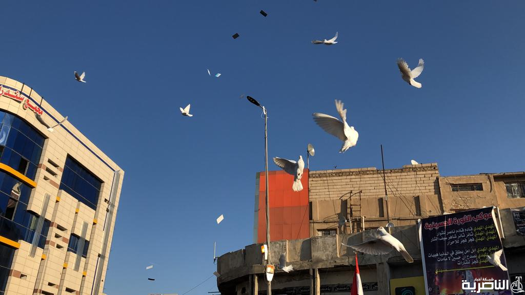 بالصور: متظاهرو الناصرية يطلقون الطيور في ساحة الحبوبي من اجل السلام