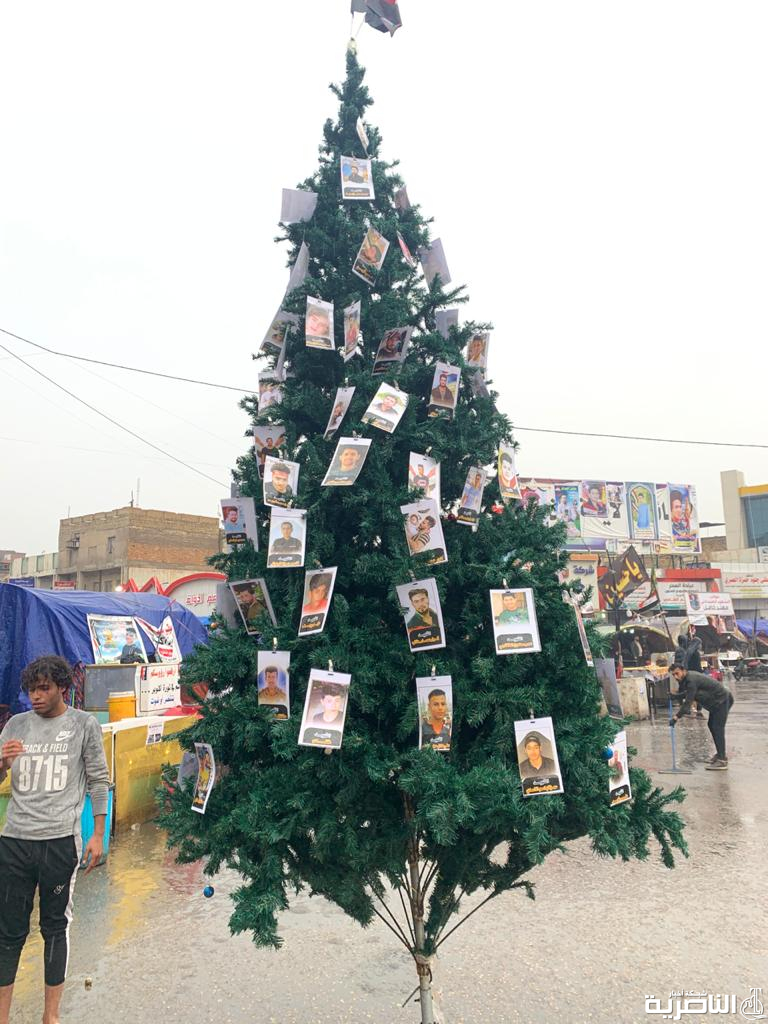بالصور: شجرة الميلاد تزينها صور الشهداء في ساحة الحبوبي بالناصرية