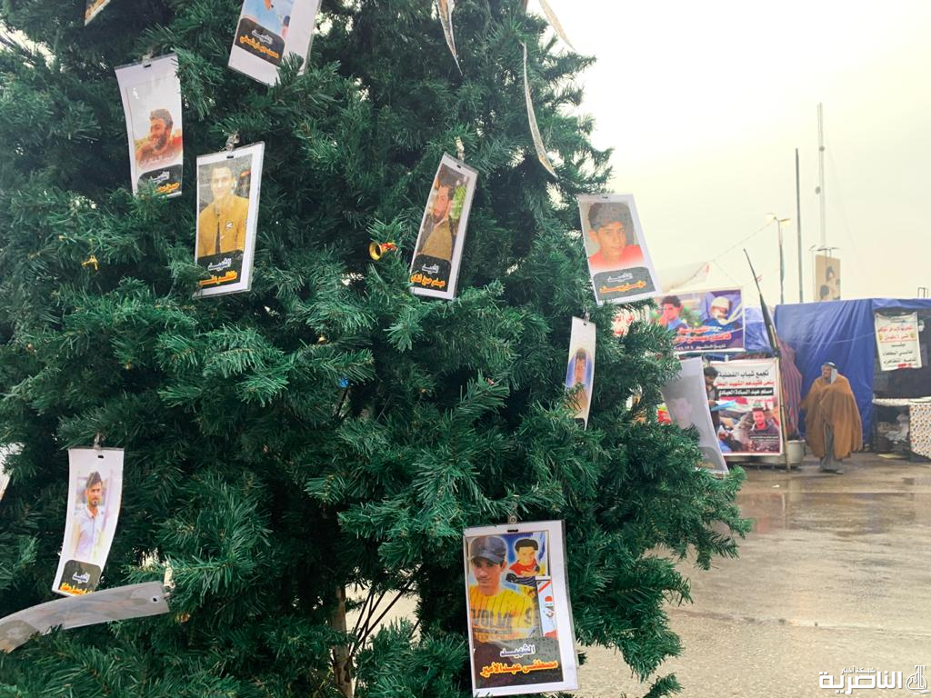 بالصور: شجرة الميلاد تزينها صور الشهداء في ساحة الحبوبي بالناصرية