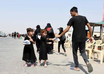 بالصور: أطفال ذي قار يتسابقون لخدمة زائري الامام الحسين عليه السلام